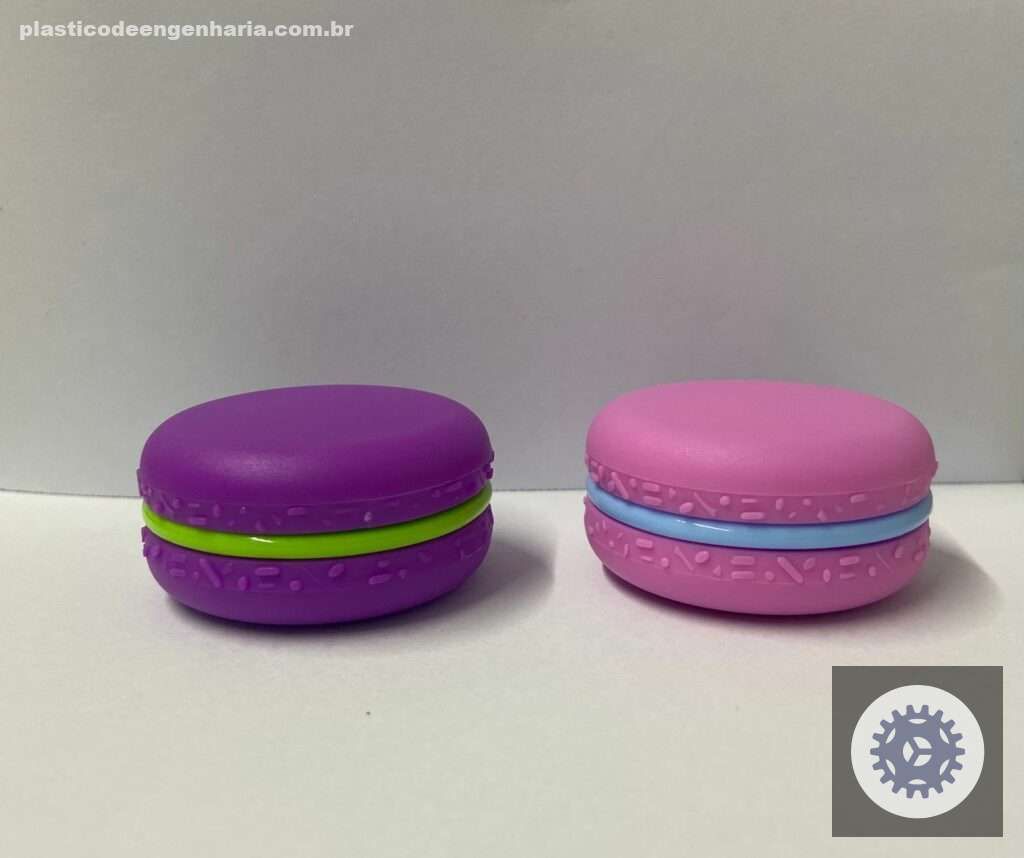 Na imagem aparecem dois lips balm em forma de macaron. Um deles é roxo com verde e o outro rosa com azul. Os cosméticos fazem parte da linha da Sabrina Sato que use desmoldante atóxico da Mirai Química para embalagens plásticas