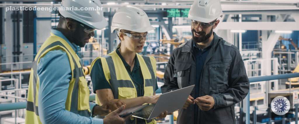 Na imagem aparecem três trabalhadores da indústria. Sendo dois homens, um negro e um branco, e uma mulher branca. O homem negro e a mulher branca estão usando colete. e os três usam capacete de proteção