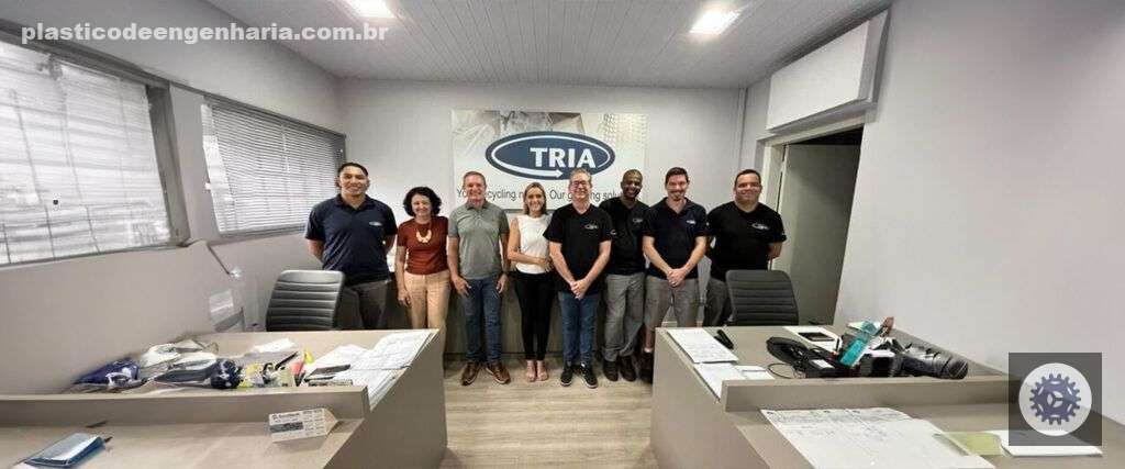 Na imagem aparece a equipe da empresa TRIA do Brasil. Lado a lado, em uma sala de cor branca